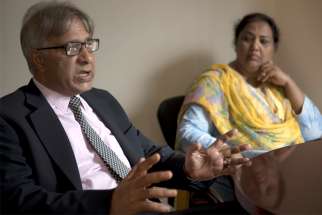 Peter Jacob, executive director of the Center for Social Justice based in Lahore, Pakistan, gestures during an interview with a Catholic News Service reporter in Washington July 18, 2019. Looking on is Rubina Feroze Bhatti of Pakistan, a founding member and current general secretary of Taangh Wasaib Organization, a rights-based development group.