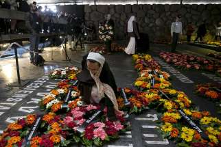 A nun lays a wreath beside the name of a former concentration camp during a ceremony titled &quot;Unto Every Person There is a Name&quot; at Yad Vashem Holocaust memorial in Jerusalem April 16, 2015. That day, Israel marked its annual Holocaust Remembrance Day, commemorating the 6 million Jews killed by the Nazis during World War II.