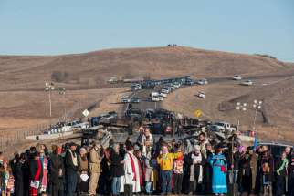 Clergy of many faiths from across the United States participate in a prayer circle Nov. 3 in front of a bridge in Standing Rock, N.D., where demonstrators confront police during a protest of the Dakota Access pipeline. Demonstrations against the pipeline are taking place on the Standing Rock Indian Reservation near Cannonball, N.D.
