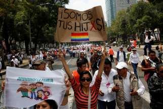 A woman holds a sign near the Angel of Independence monument in support for the legalization of same-sex marriage during a Sept. 24 protest in Mexico City. A congressional committee has voted against changing the constitution to allow for same-sex marriage.