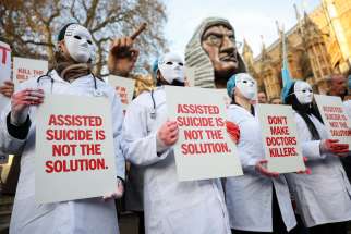 Protestors holds a placard outside Parliament as British lawmakers debate the assisted dying law in London Nov. 29, 2024. Britain&#039;s lawmakers voted Nov. 29 to legalize assisted suicide for the terminally ill in England and Wales, despite opposition from Britain&#039;s Catholic bishops and other faith groups.