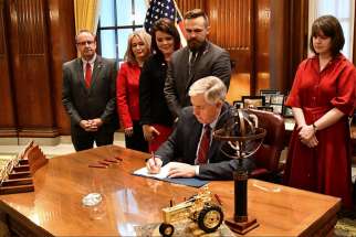 Missouri Gov. Mike Parson signs a bill into law banning abortion beginning in the eighth week of pregnancy, alongside state House and Senate members and pro-life coalition leaders at his office in Jefferson City May 24, 2019.