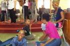 A volunteer, top right, looks on as a family with an autistic child left, attends Mass July 8 at Holy Trinity Church in Arouca, Trinidad.