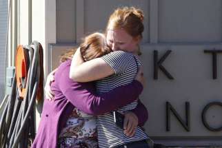 Umpqua Community College alumna Donice Smith, left, is embraced after learning one of her former teachers was killed in Roseburg, Ore., Oct. 1.