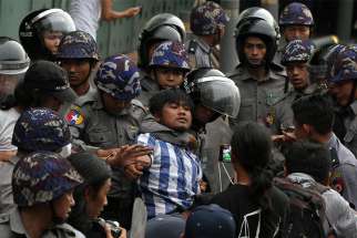  Police officers detain a student taking part in a rally demanding peace May 12 at the war-torn section of Yangon, Myanmar.