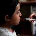 A nurse uses a syringe to give medicine to a girl at San Jose Hospice in Sacatepequez, Guatemala, Nov. 30. About 68 HIV-infected patients, infants to those 18 years old, receive free medical care at the hospice.