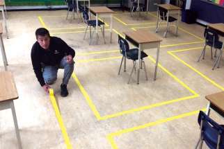 Tape is placed on the floors of St. Helen’s Elementary School in Burnaby, B.C., marking where students will sit to maintain physical distancing.