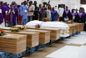 Flowers lie on caskets during a funeral Mass for some of the 40 victims killed in a 2022 attack by gunmen during Mass in Nigeria. Nigeria figures prominently in Pew Research’s latest report on religious persecution around the world.