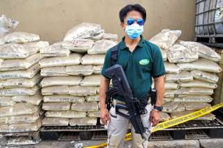 An agent of the Philippine Drug Enforcement Agency stands guard June 16 in front of chemicals used in the production of crystal meth, or Shabu, near Manila, Philippines. Philippine church leaders expressed words of caution in the wake of recent killings of suspected criminals, after voters there elected Rodrigo Duterte, who ran for president on the promise to rid the country of crime during his first six months in office.