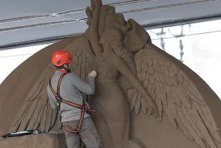  A worker sculpts an angel on a Nativity scene made entirely of sand in St. Peter&#039;s Square at the Vatican Nov. 26. The 52-foot wide sculpture is made of sand from Jesolo, an Italian seaside town near Venice. 