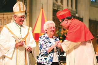 Sr. Teresita McInally receives the Pro-Ecclesia et Pontifice Cross from Quebec’s Cardinal Gerald Lacroix as Hamilton Bishop Douglas Crosby looks on.