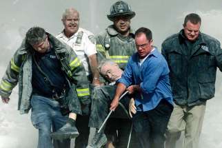 Rescue workers carry fatally injured New York City Fire Department chaplain, the Rev. Mychal Judge, from the wreckage of the World Trade Center in New York City on Sept. 11, 2001.