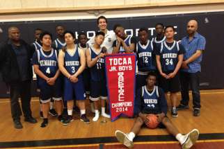 Autistic student Ramy Elsayed (back centre) serves as the equipment manager for St. Mary’s Catholic High School junior boys basketball team.