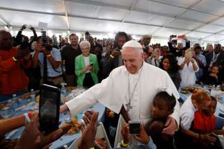 A girl hugs Pope Francis as he visits with people at St. Maria&#039;s Meals Program of Catholic Charities in Washington Sept. 24