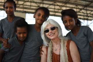 Emmylou Harris poses with young refugees at Adi-Harush refugee camp in northern Ethiopia. Harris, who has won more than a dozen Grammy awards during a 45-year career singing country music, is headlining a series of concerts this fall to benefit Jesuit Refugee Service.