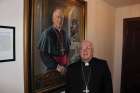 Outgoing Ottawa-Cornwall Archbishop Terrence Prendergast stands beside a portrait of himself.