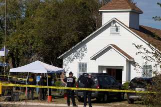 Law enforcement officers stand near the scene of a mass shooting Nov. 5 at the First Baptist Church in Sutherland Springs, Texas. A lone gunman entered the church during Sunday services taking the lives of at least 26 people and injuring several more.