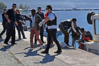 Coast Guard members help refugees to disembark April 17 at the port of Kalamata in Greece. The survivors told U.N. staff that they had been part of a group of between 100 and 200 people who departed from Libya the previous week. There are reports of up to 500 refugees drowning in the Mediterranean Sea.