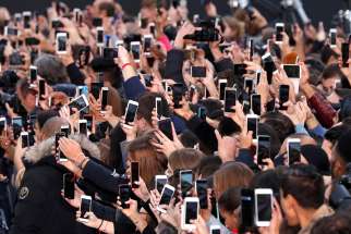 People use their smartphones to take photos of the Pope in Paris, France, Oct. 1. MissioBot is available for the entire month of October in commemoration of World Mission Sunday, Oct. 22.
