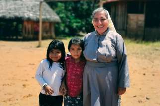 Sr. Rosa Elena Pico, a member of the Missionaries of Mary Co-Redemptrix, poses with children from the Indigenous community of Sarayaku, Ecuador. Pico has worked in the community since 2017 and occasionally leads the liturgy of the word in the absence of a priest.