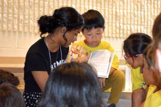Missionary Abigail Muree reads to youngsters attending the Totus Tuus summer program in 2019.