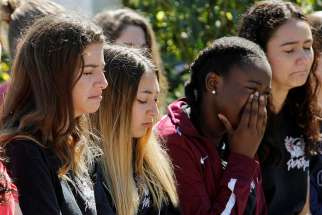 Students mourn during a Feb. 15 prayer vigil in Pompano Beach, Fla., for victims of the shootings at nearby Marjory Stoneman Douglas High School in Parkland. At least 17 people were killed in the shooting. The suspect, 19-year-old former student Nikolas Cruz, is in custody.