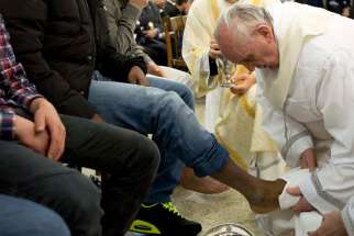Pope Francis washes the foot of an inmate during the Holy Thursday Mass at Casal del Marmo prison for minors in Rome in this March 28, 2013, file photo. Following a request by Pope Francis, the Vatican issued a decree Jan. 21 specifying that the Holy Thursday foot-washing ritual can include women.