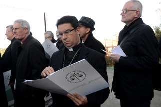 Bishop Oscar Cantu of Las Cruces, N.M., looks at documents explaining the proposed Israeli security wall in the West Bank&#039;s Cremisan Valley Jan. 13. Bishop Cantu is part of the Holy Land Coordination visit for bishops from Europe and North America.