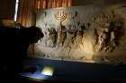 A journalist looks at a replica of the 1st-century Arch of Titus, showing Roman soldiers carrying the menorah, in a exhibition at the Vatican May 15. The replica is the central motif in a two-part exhibition on the menorah at the Vatican and at the Jewish Museum in Rome.