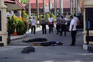  The bodies of two attackers who were shot and killed May 16 are seen at the entrance of a police station in Pekanbaru, Indonesia.