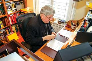 Cardinal Thomas Collins goes over the large collection of paperwork that accumulates throughout the day.