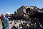 Local residents stand next to the debris of a house hit by a mortar shell from the Syrian side of the border in Alanyurt village near the Turkish-Syrian border Sept. 29. A Syrian priest on a U.S. mission trip says amid ongoing death and destruction in th e Middle East, the Catholic Church continues to provide spiritual and material support for those in need.