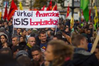People hold a banner during an Oct. 12 demonstration in Berlin against the Islamic State militant group, known as ISIS, and its insurgent attacks on the Syrian Kurdish town of Kobani. Muslim leaders worldwide have issued a stern rebuke to ISIS.