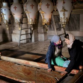 Christian pilgrims touch the Stone of Unction, which commemorates the anointing of Jesus before his burial, inside the Church of the Holy Sepulcher in Jerusalem March 29. Although the stone&#039;s connection to Christ&#039;s burial is improbable, that does not det er believers from devotion. The stone has been smoothed by centuries of veneration.