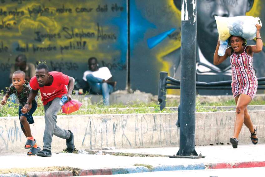 People take cover from gunfire near the National Palace in Port-au-Prince, Haiti. 