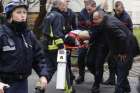 Firefighters carry a victim on a stretcher at the scene of a shooting at the Paris offices of Charlie Hebdo, a satirical newspaper, Jan. 7. Pope Francis condemned the killings of at least 12 people at the offices and denounced all &quot;physical and moral&quot; ob stacles to the peaceful coexistence of nations, religions and cultures. 
