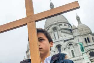 A boy stands with cross outside Sacre Coeur basilica in Paris April 3. Catholic churches in France have been placed under police protection and urged to take extra security measures against possible Islamist attacks before the Aug. 15 feast of the Assumption. 