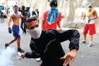 A demonstrator throws back a tear gas canister while clashing with the Venezuelan National Guard Jan. 21 during a protest close to one of their outposts in Caracas. 