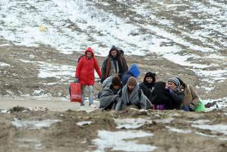 A group of migrants from Syria, Iraq and Afghanistan, on their way to seek asylum in Germany or Austria, walk Jan. 24 along the frozen route from the border between Serbia and Macedonia to a temporary camp for migrants. 