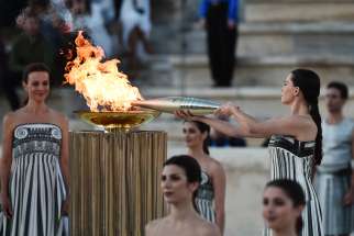 A dancer lights the torch during the Olympic flame handover ceremony for the Paris 2024 Summer Olympics at Panathenaic Stadium in Athens, Greece, April 26, 2024.