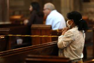A woman prays during Mass at the Catholic Church of the Immaculate Conception in London July 4, 2020, during the COVID-19 pandemic. Catholic leaders in England are appealing to the government to reverse its decision to ban public Mass during a second national lockdown.