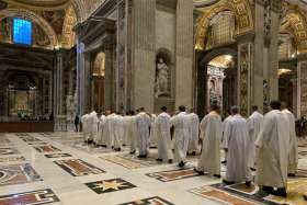 Priests in St. Peter&#039;s Basilica process to the altar where St. John Paul II is buried at the Vatican in this Feb. 13, 2020, photo. Dozens of priests concelebrate an early morning Mass at the tomb every Thursday.