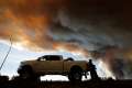 People wait at a roadblock May 7 as smoke rises from wildfires near Fort McMurray, Alberta. Pope Francis has added his name to the list of people offering condolences to those affected by the massive forest fire that has led to the evacuation of Fort McMurray.