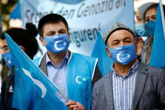 A man holds a Uyghur flag at a rally in Berlin during the visit of China&#039;s Foreign Minister Wang Yi Sept. 1, 2020. The religious persecution exercised by China and North Korea, restrictions on religious freedom in dozens of countries and the continuing threat of violence at the hands of religious fundamentalists belonging to a variety of faiths all have worsened since 2018, said Aid to the Church in Need, a papal foundation and Catholic charity.