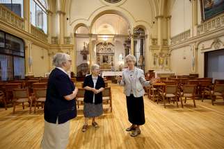 Ursuline Sister Cecile Dionne speaks to Sister Pauline Duchesne and Sister Celine Bergeron inside Quebec City&#039;s Ursuline monastery chapel June 1. In October, the majority of the 50 sisters who live in the monastery, founded by St. Mary of the Incarnation, will head to the borough of Beauport, where a new home for the elderly awaits them.