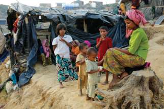 A Rohingya family sits outside their tent at a refugee camp in Cox’s Bazar, Bangladesh. 