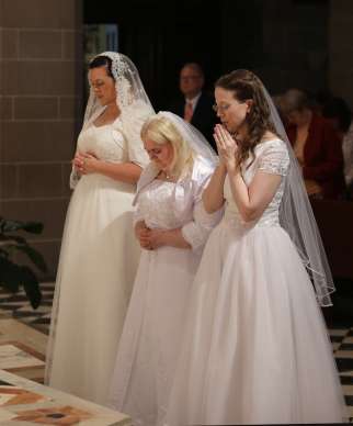 Karen Ervin, Theresa Jordan and Laurie Malashanko pause in prayer before the altar at Detroit&#039;s Cathedral of the Most Blessed Sacrament in 2017. They were consecrated into the Catholic Church&#039;s order of virgins. 