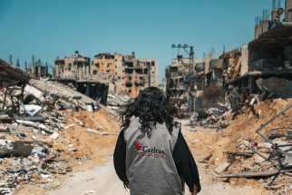 A Caritas worker walks through destroyed buildings in Gaza City March 16, 2024.