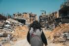 A Caritas worker walks through destroyed buildings in Gaza City March 16, 2024.