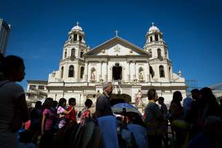 People stroll in front of the Minor Basilica of the Black Nazarene in Manila, Philippines, in this 2014 file photo.
